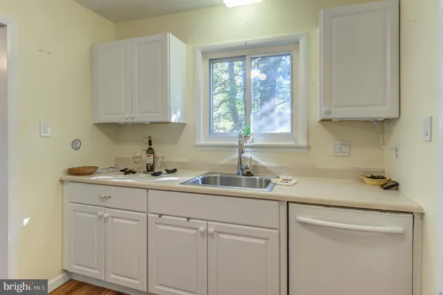 a kitchen with a sink cabinets and window