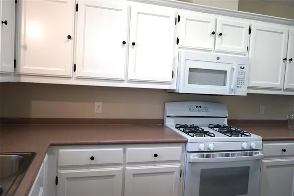 a stove top oven sitting inside of a kitchen