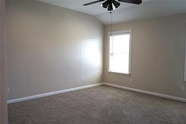 an empty room with a window and a ceiling fan