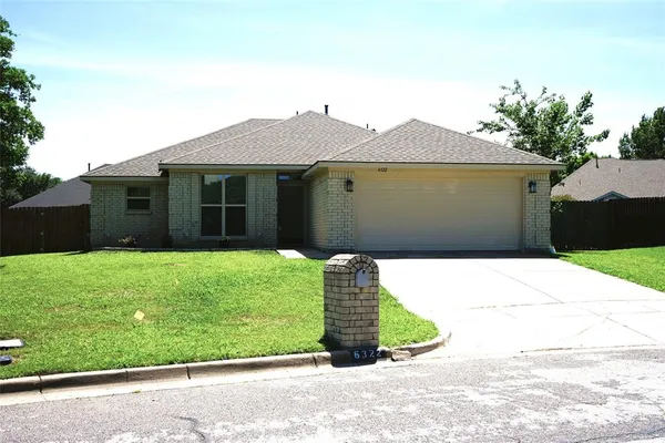 a front view of a house with a garden and yard