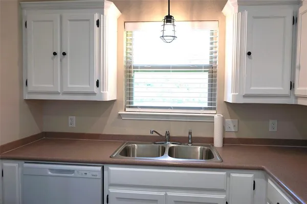 a kitchen with a sink cabinets and a window