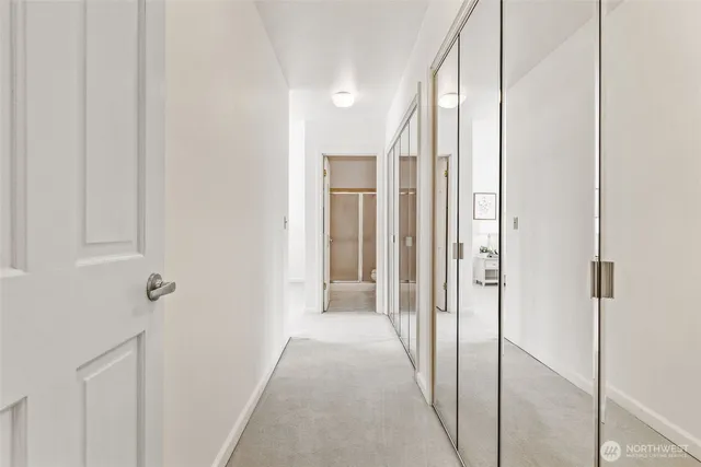 a view of a hallway with wooden floor and closet