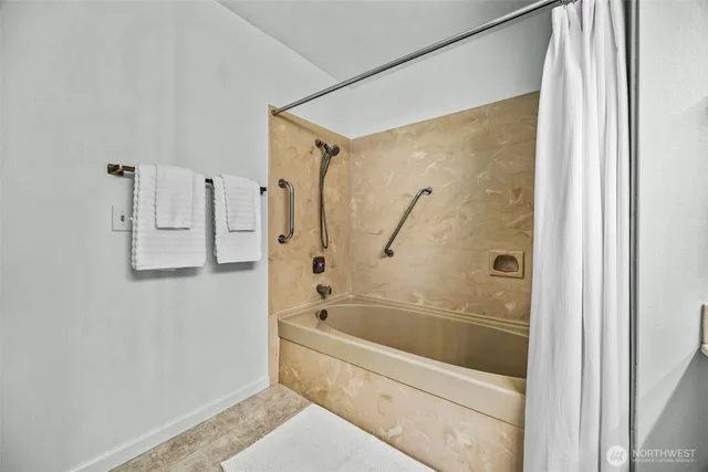 a white bath tub sitting next to a shower