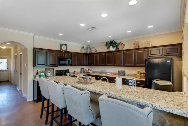 a kitchen with stainless steel appliances granite countertop a table chairs sink refrigerator and microwave