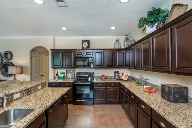 a kitchen with stainless steel appliances granite countertop a sink a stove and a refrigerator