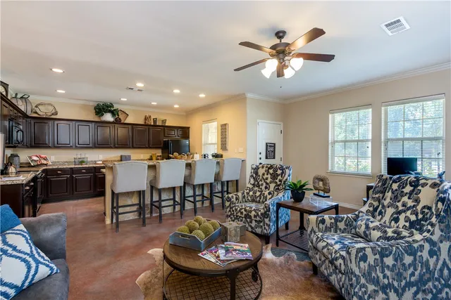 a living room with furniture kitchen view and a large window