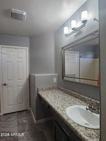a bathroom with a granite countertop sink and a mirror