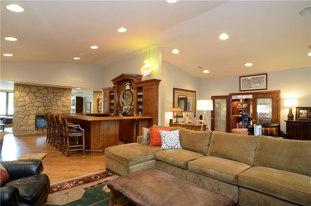 181 Merriman Road Sewickley Heights, PA 15143 - Photo 14 of 25 Incredible family room with hardwood flooring, bar and two-sided stone fireplace.