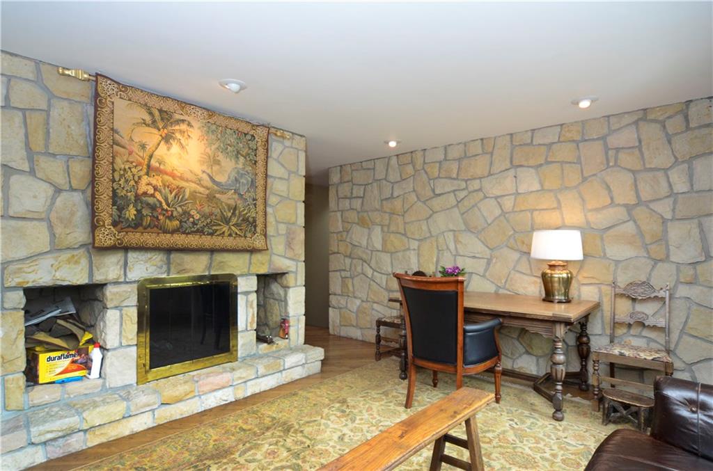 181 Merriman Road Sewickley Heights, PA 15143 - Photo 7 of 25 Comfortable conversation room with hardwood flooring and floor to ceiling two -sided stone fireplace.