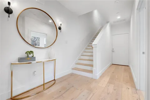 an entryway with wooden floor and staircase