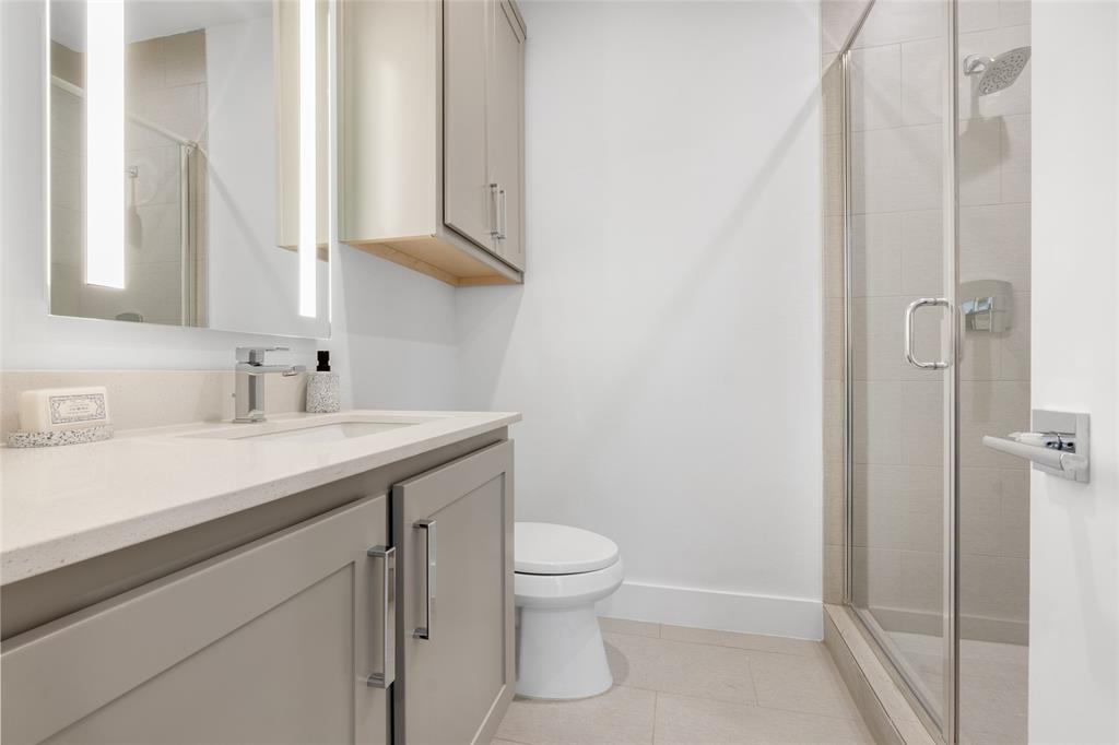 3915 North Hall Street, Unit 202 Dallas, TX 75219 - Photo 4 of 18 a bathroom with a sink a toilet and shower