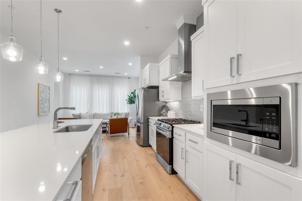 3915 North Hall Street, Unit 202 Dallas, TX 75219 - Photo 6 of 18 a kitchen with stainless steel appliances granite countertop a sink a stove and a refrigerator