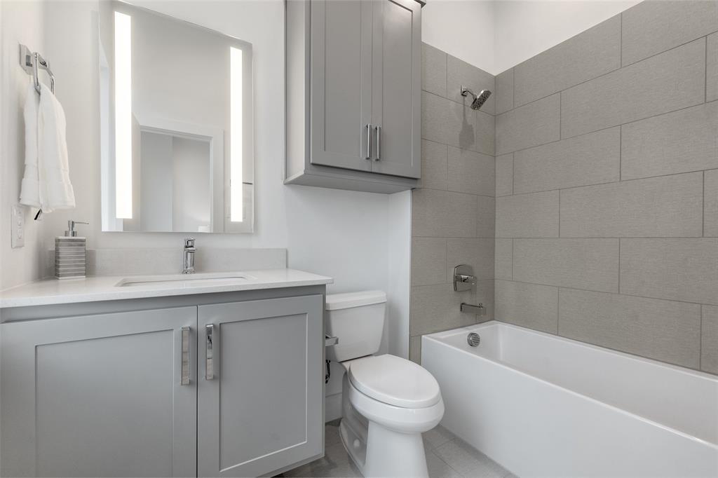 3915 North Hall Street, Unit 202 Dallas, TX 75219 - Photo 10 of 18 a bathroom with a sink a toilet and bathtub