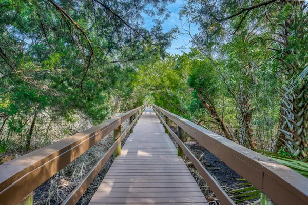 a living room with furniture and a dining table with wooden floor