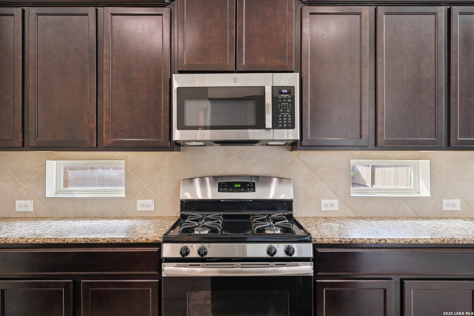 8722 Study Butte San Antonio, TX 78254 - Photo 15 of 40 a kitchen with granite countertop wooden cabinets and stainless steel appliances