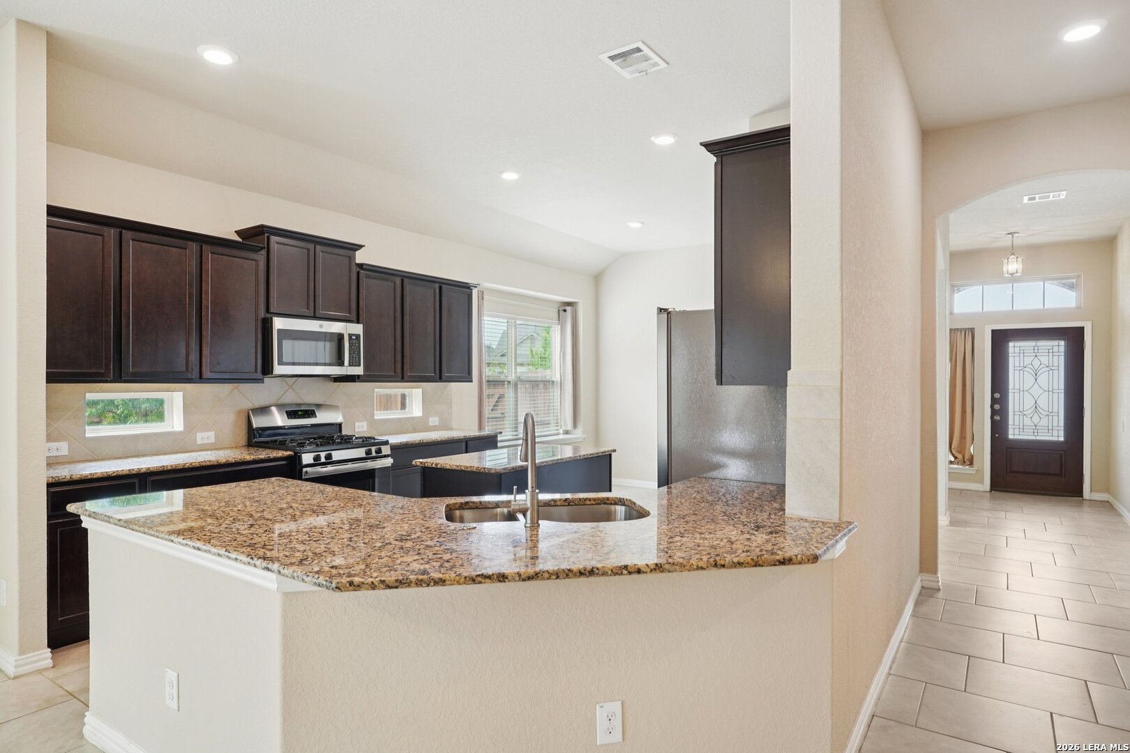 8722 Study Butte San Antonio, TX 78254 - Photo 16 of 40 a kitchen with granite countertop a sink a stove and cabinets