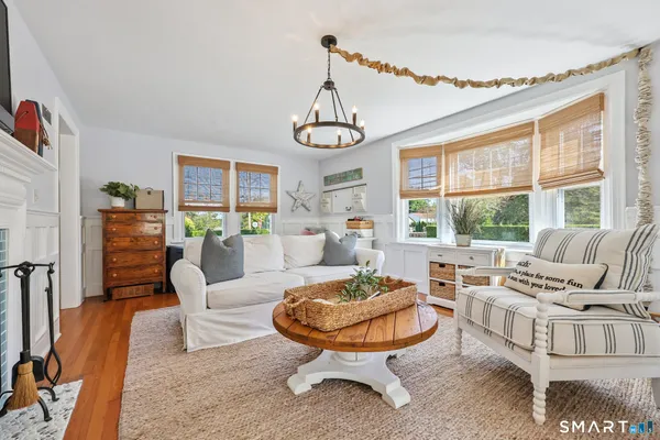 a living room with furniture a fireplace and a chandelier