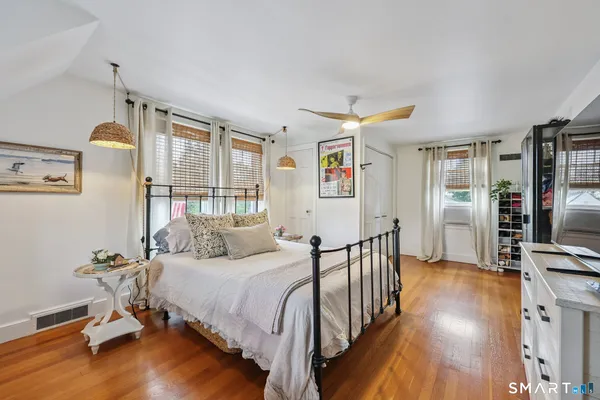 a bedroom with a bed and wooden floor