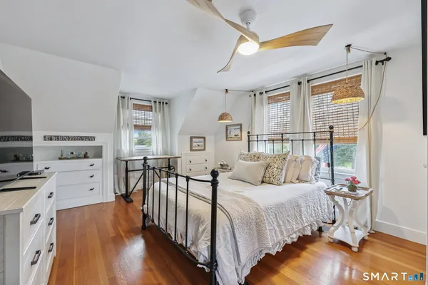 a bedroom with furniture a bed and a flat tv screen on dresser