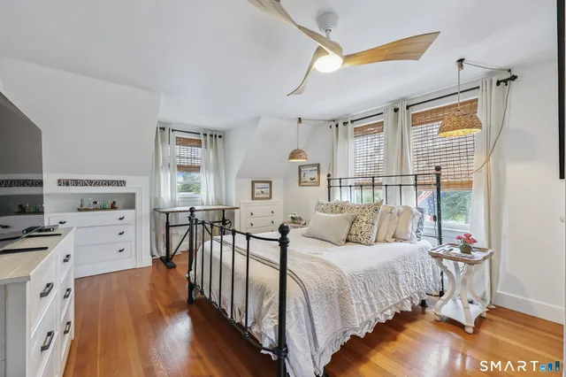 a bedroom with furniture a bed and a flat tv screen on dresser