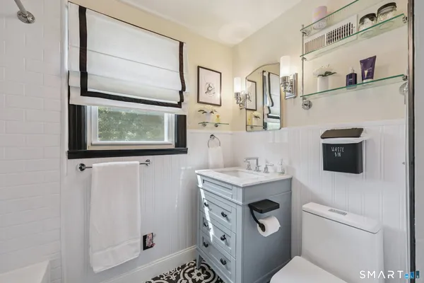 a bathroom with a toilet sink and mirror