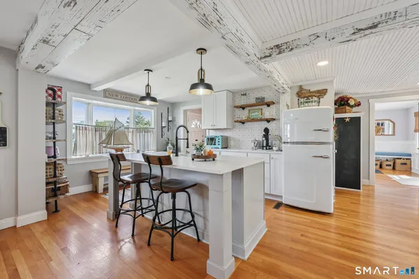 a kitchen with stainless steel appliances kitchen island hardwood floor sink and dining table