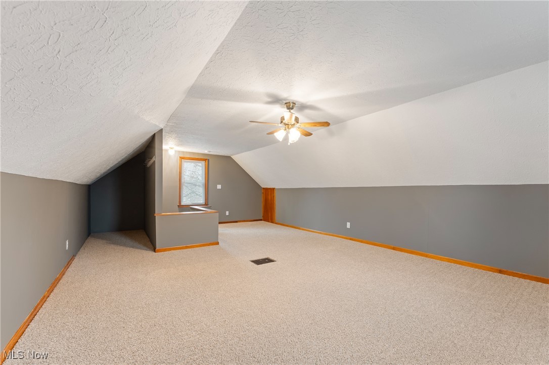 631 Killinger Road Clinton, OH 44216 - Photo 22 of 50 Additional living space featuring a textured ceiling, ceiling fan, light carpet, and lofted ceiling