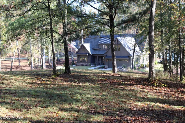 a front view of a house with a tree