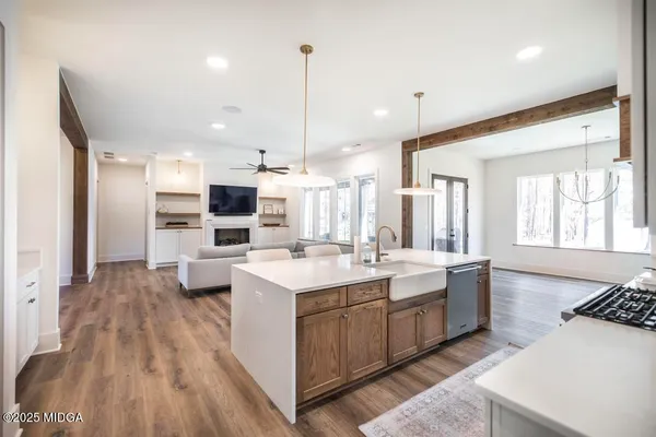 a large kitchen with kitchen island a sink stainless steel appliances and white cabinets