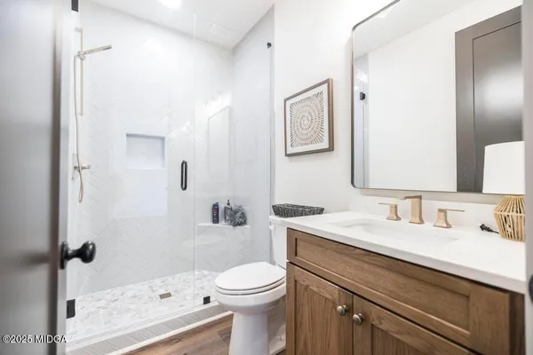 a bathroom with a sink a toilet and shower