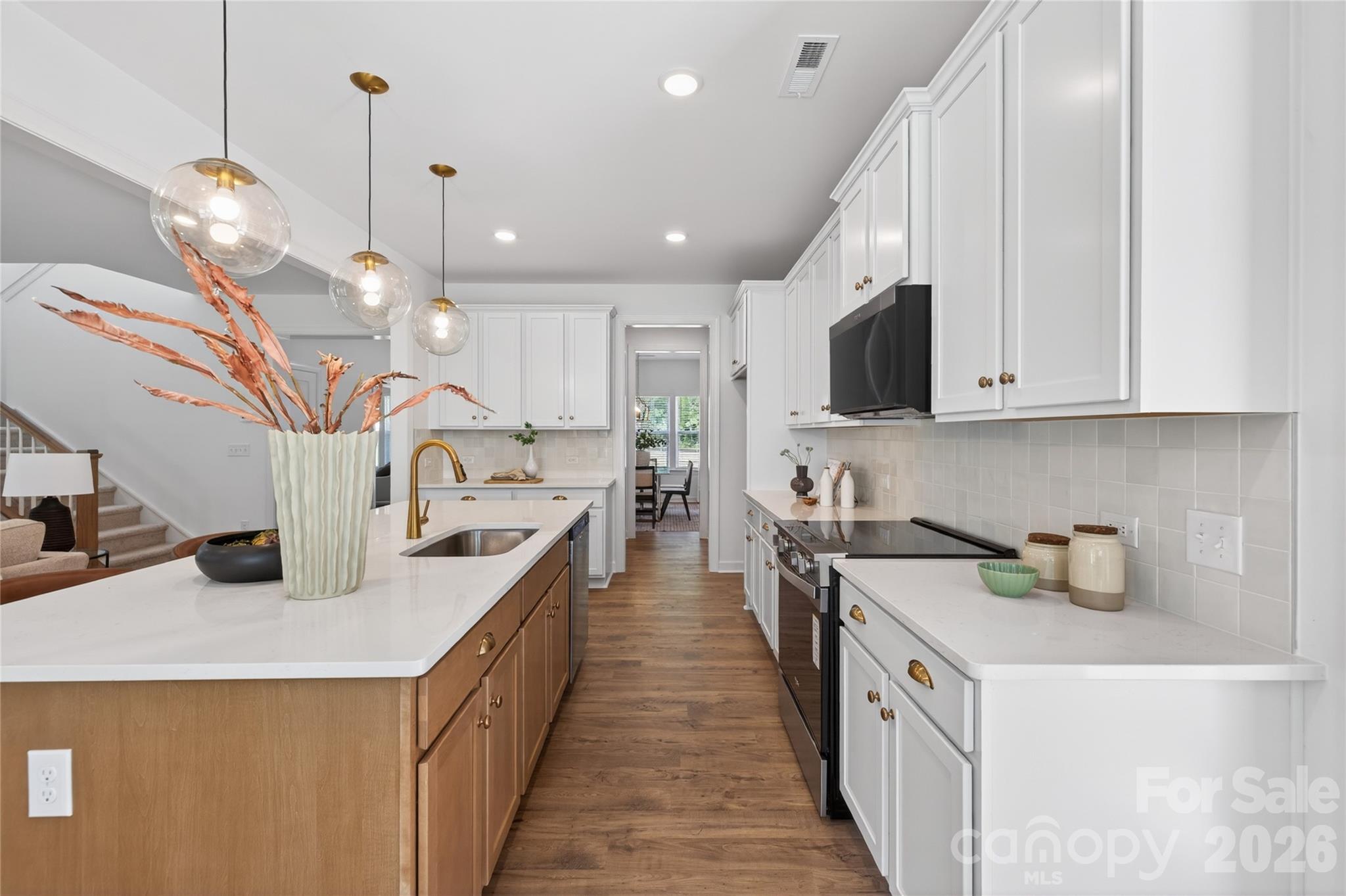 128 Overcash Road, Unit 7171 Troutman, NC 28166 - Photo 6 of 41 a kitchen with kitchen island granite countertop a sink a counter top space appliances and cabinets