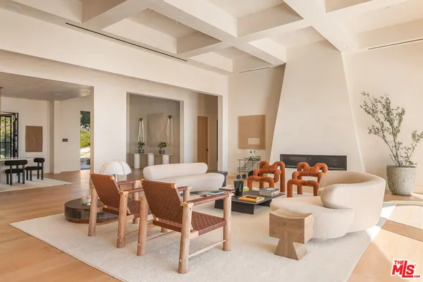 a dining room with wooden floor a chandelier a wooden table and chairs