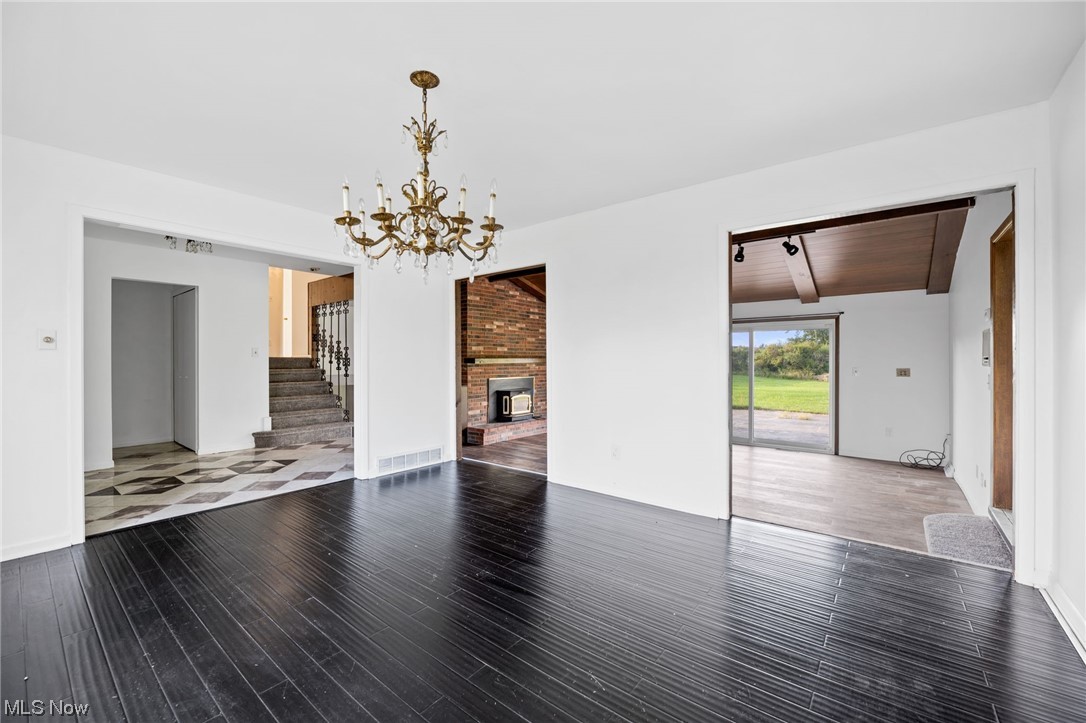 27299 Belgrave Road Cleveland, OH 44124 - Photo 7 of 11 Dining room with a notable chandelier, lofted ceiling with beams, wood ceiling, and a fireplace