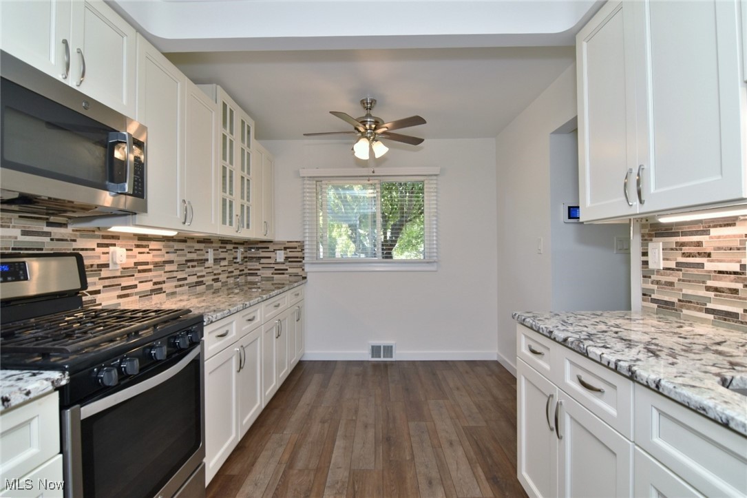 981 Hanley Road Cleveland, OH 44124 - Photo 10 of 42 Kitchen with decorative backsplash, stainless steel appliances, and white cabinetry