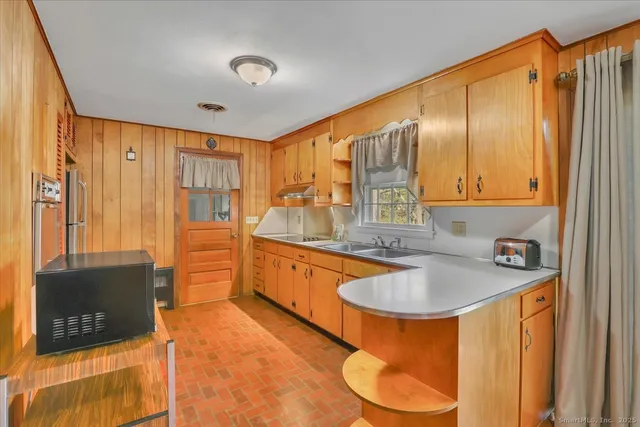 a kitchen with stainless steel appliances granite countertop a sink a stove and a refrigerator with wooden floor