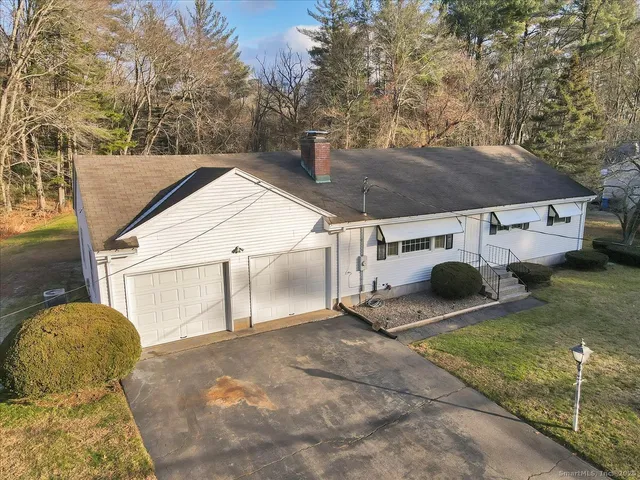 a view of a white house with a yard and garage