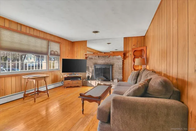 a living room with furniture a flat screen tv and a fireplace