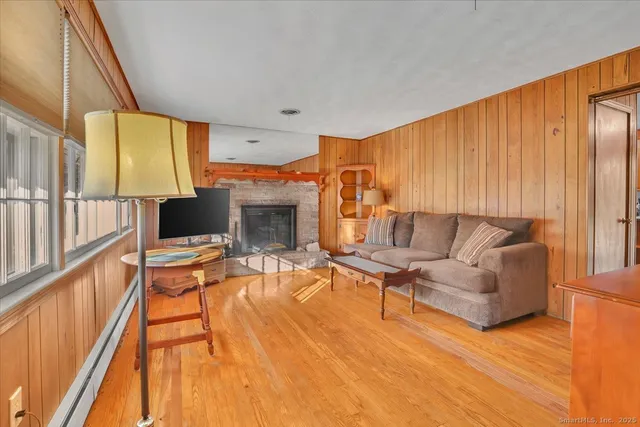a living room with furniture a fireplace and a floor to ceiling window