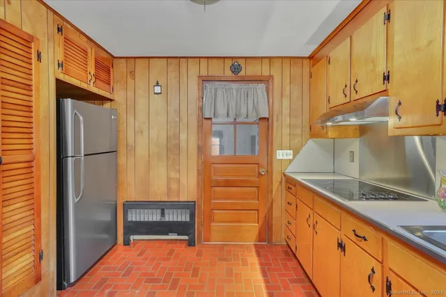 a kitchen with granite countertop a refrigerator and a sink