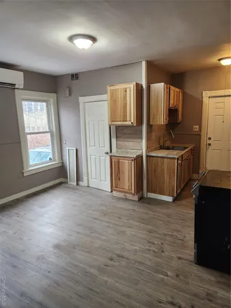 an empty room with kitchen wooden floor and windows