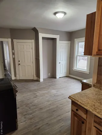 an empty room with window and wooden floor
