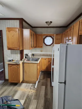 a kitchen with granite countertop a refrigerator a stove and wooden floor