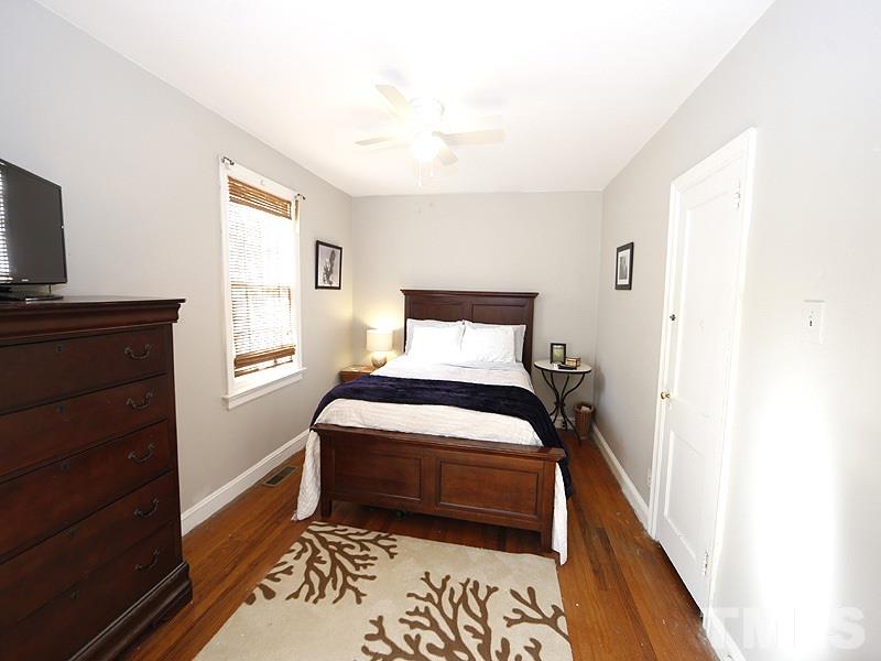 2613 Van Dyke Avenue Raleigh, NC 27607 - Photo 15 of 24 a bedroom with a bed and a flat tv screen on a dresser