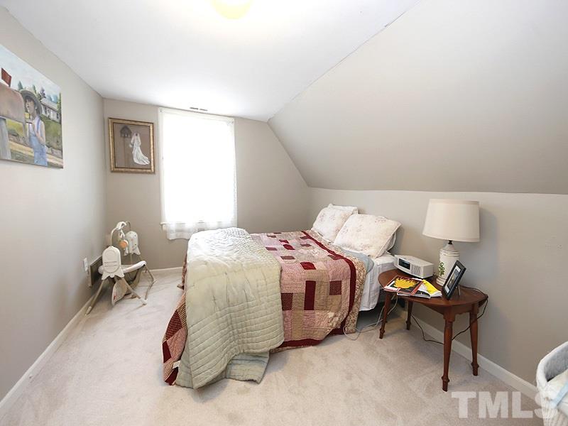 2613 Van Dyke Avenue Raleigh, NC 27607 - Photo 20 of 24 a bedroom with a bed and a chair