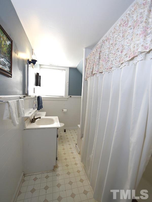 2613 Van Dyke Avenue Raleigh, NC 27607 - Photo 21 of 24 a bathroom with a sink a mirror and a shower