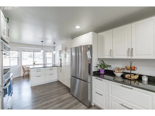 a kitchen with a refrigerator and white cabinets