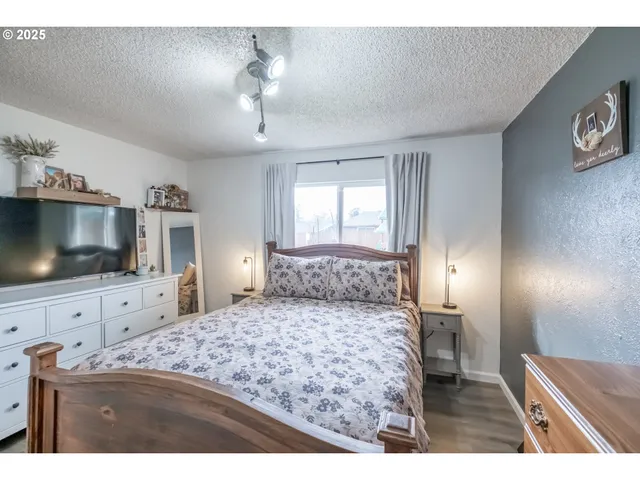 a living room with a bed and a flat screen tv