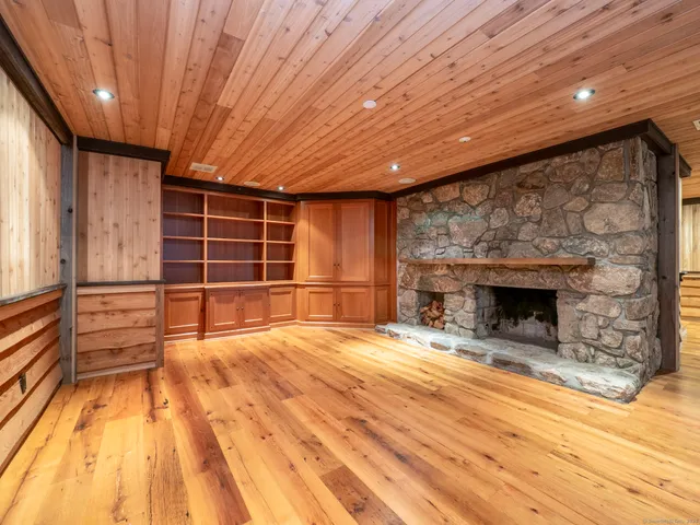 a view of empty room with wooden floor and fireplace