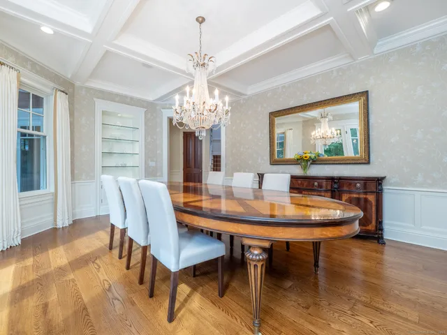 a dining room with furniture a chandelier and wooden floor