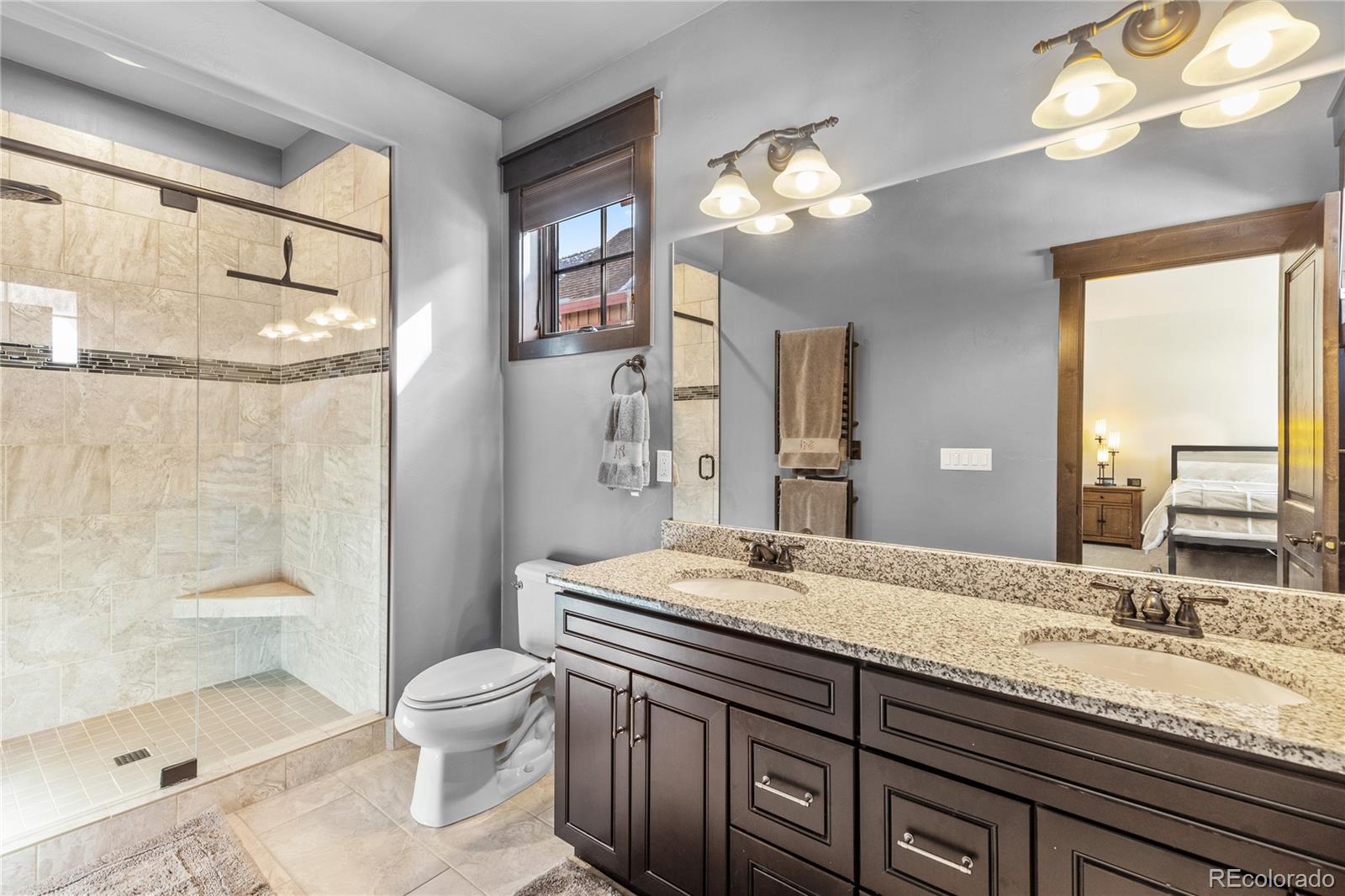 68 Independence Road Keystone, CO 80435 - Photo 19 of 34 a bathroom with a granite countertop sink a toilet and a large mirror